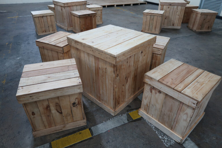 Table and chairs made of light brown wood, located at the parking lot.